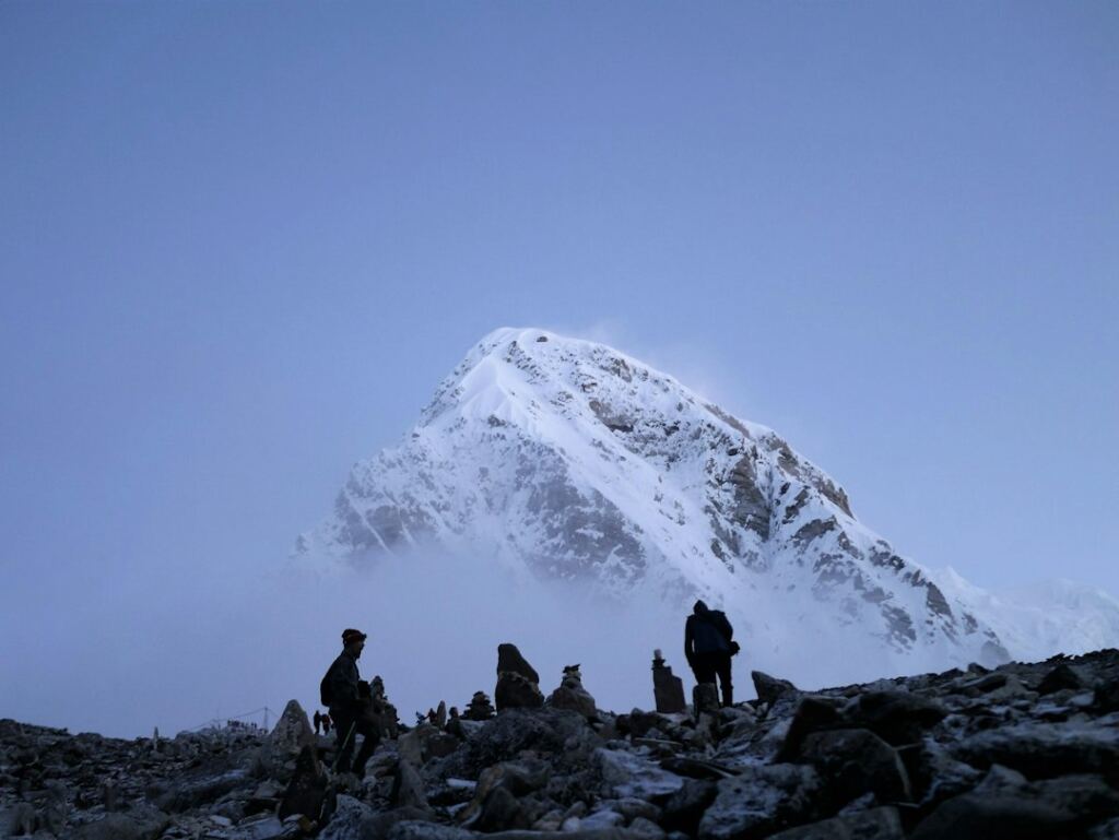 Mountaineers in the Nepal Himalaya with a snow-covered mountain, representing the 1953 Everest ascent