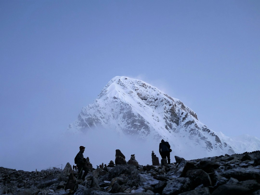 Mountaineers in the Nepal Himalaya with a snow-covered mountain, representing the 1953 Everest ascent