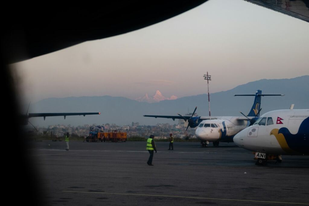 Aircraft on an airport runway in Nepal representing return migration and departure