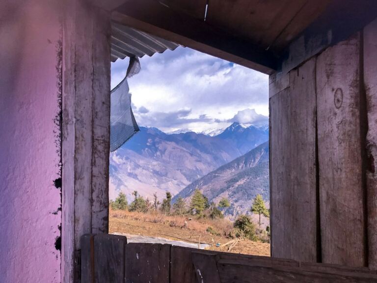 Mountain view through a window in Nepal, representing memory, home and belonging for the Nepali diaspora