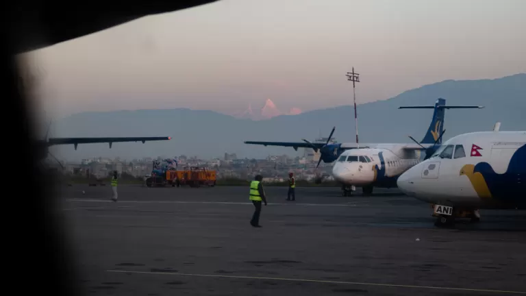 Aircraft on a runway in Kathmandu, representing diaspora travel home to Nepal