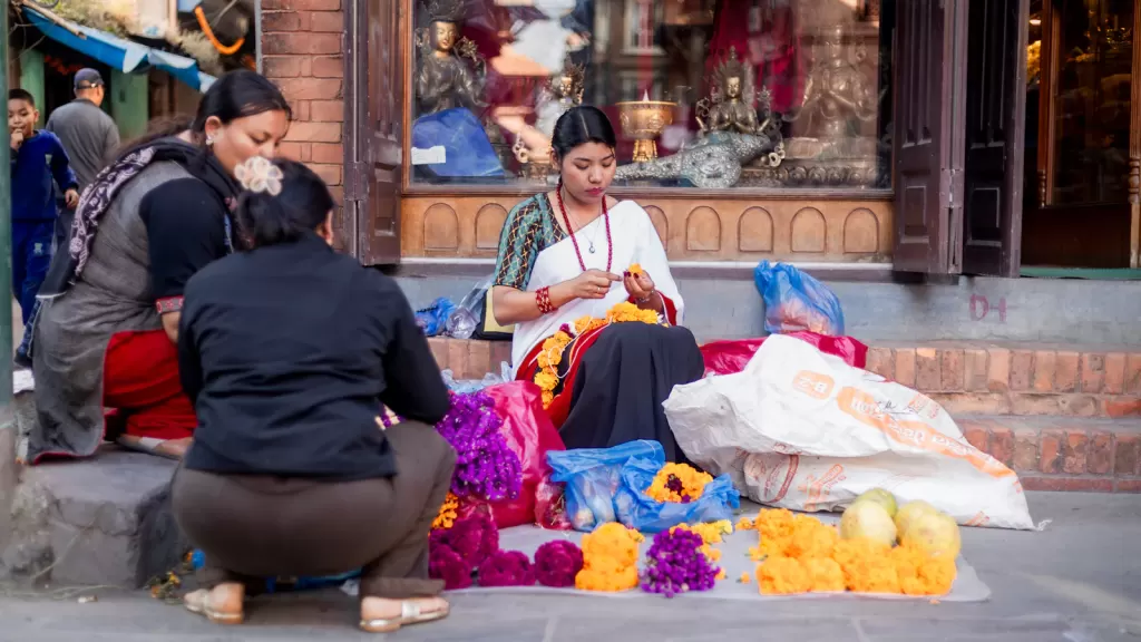 Women selling colourful flowers at a local street market in Nepal, illustrating small-scale entrepreneurship