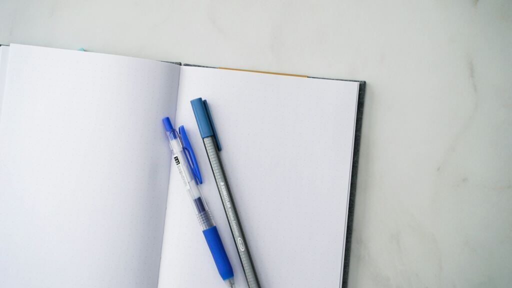 Notebooks and a pen on a desk, illustrating practical document preparation