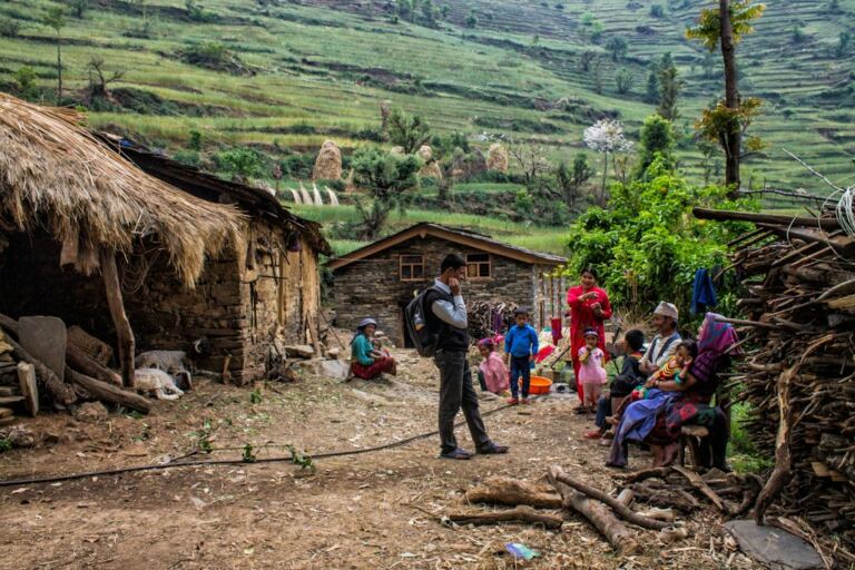 People gathered outside homes in a rural Nepali community