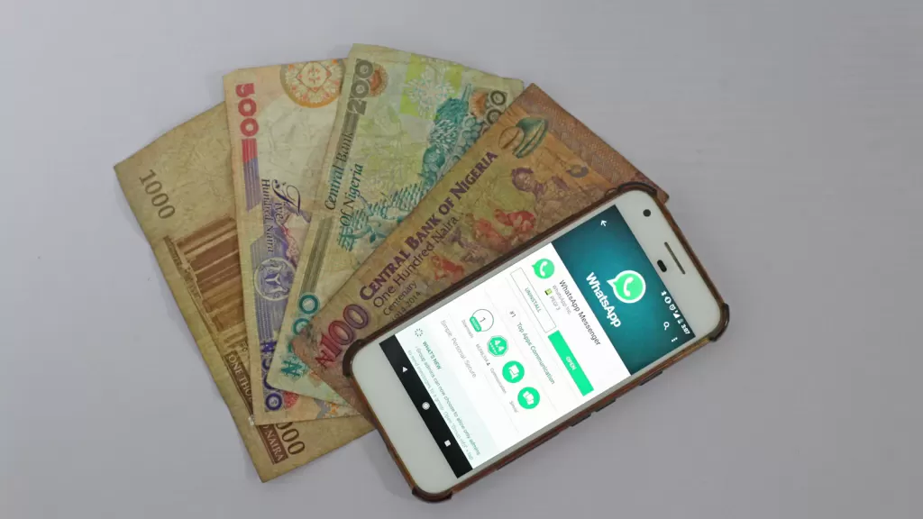 A smartphone beside banknotes, symbolising digital money transfers and remittances