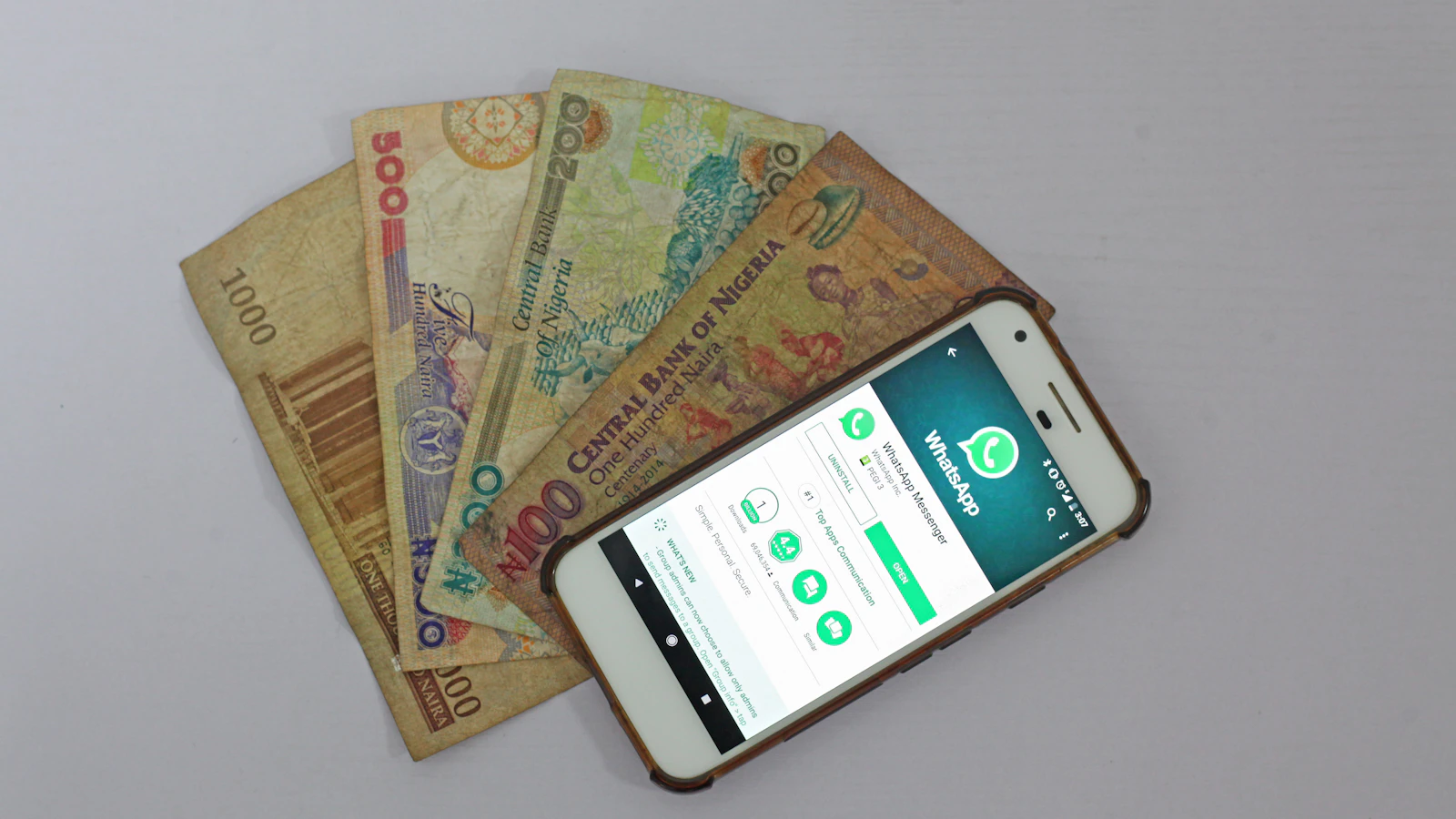 A smartphone beside banknotes, symbolising digital money transfers and remittances