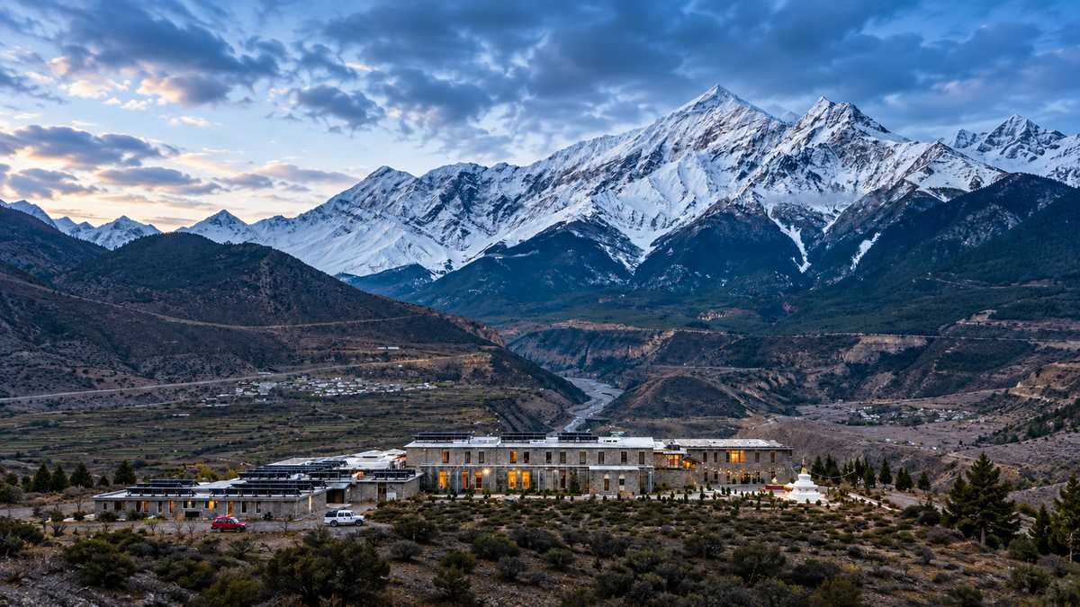 Shinta Mani Mustang hotel beneath snow-covered Himalayan peaks in Mustang, Nepal